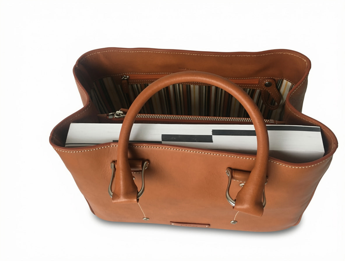 Tobacco Allegra leather tote bag viewed from above, showing rolled handles, books inside, striped lining, and a zippered compartment.