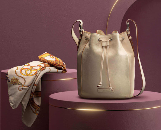 vory Febe leather bucket bag styled on mauve pedestals with silk scarf