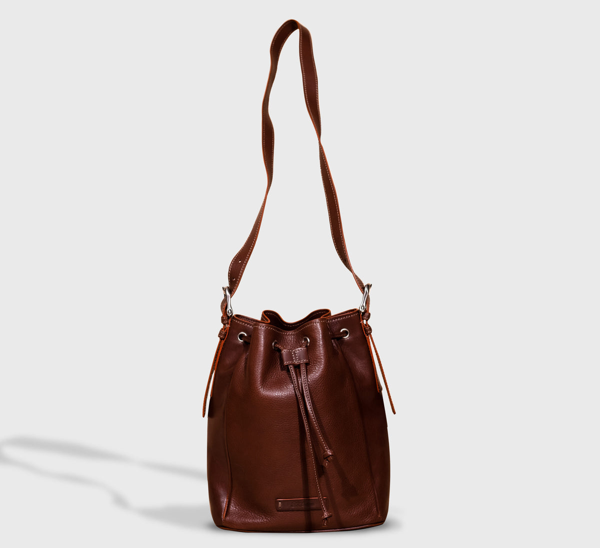 Febe Italian leather bucket bag in dark brown, worn crossbody — EKOńeu