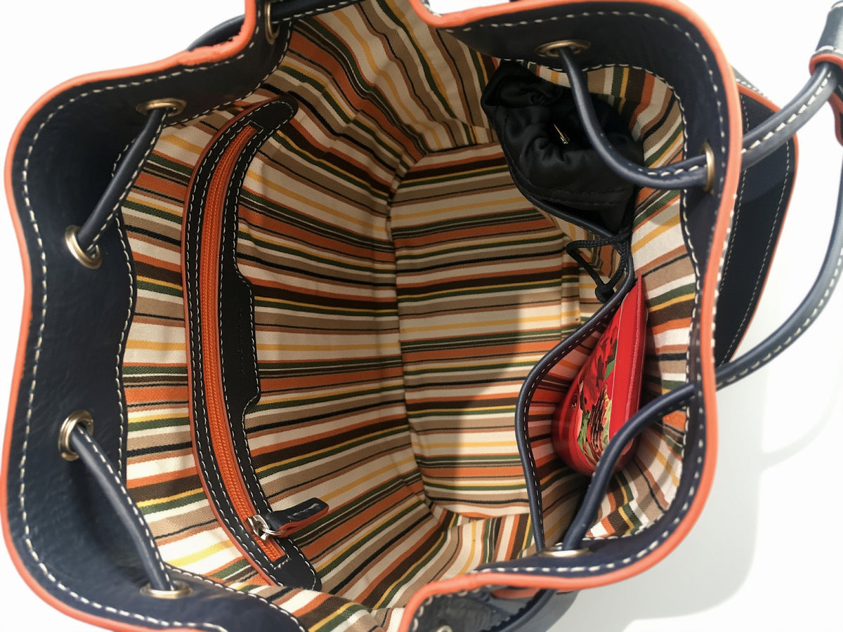 Open interior of the blue Febe leather bucket bag showing striped lining, a zipped pocket, and open compartments.