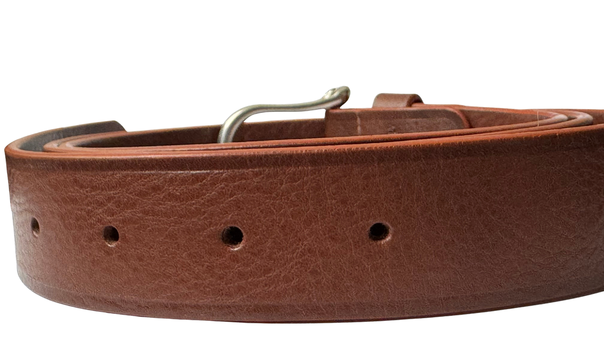 Close-up of brown Daniela leather belt showing leather grain, adjustment holes, and contrasting reddish finished edges.